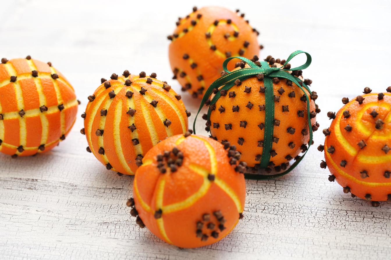 Oranges studded with whole cloves in spiral patterns